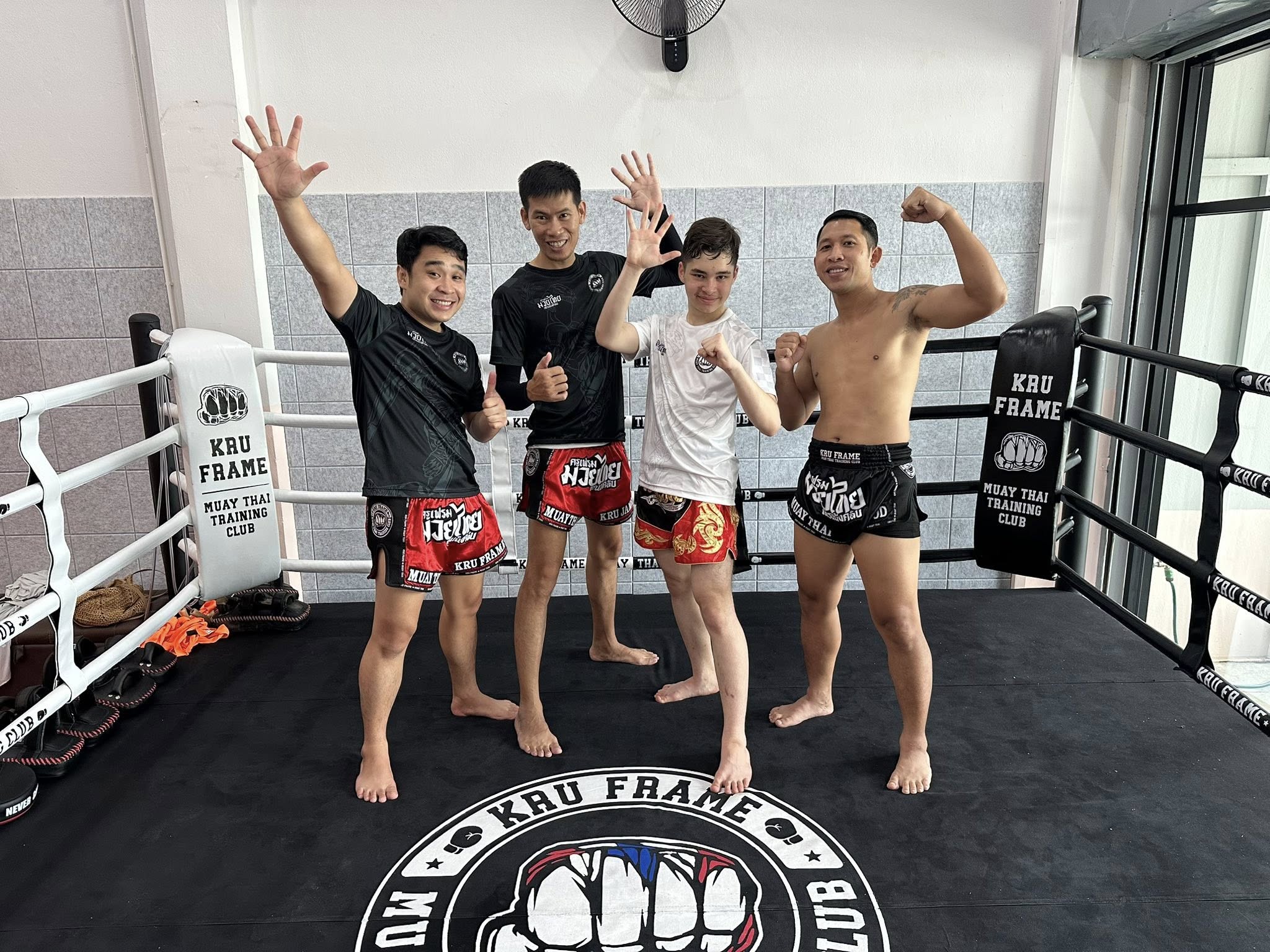Group of Muay Thai students and trainers stretching and preparing before a class at Kru Frame Muay Thai Training Club in Chiang Mai