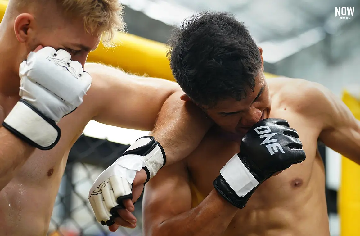 A Muay Sok practitioner landing a horizontal elbow (Sok Tad) to the opponent’s jaw in close-quarters combat.