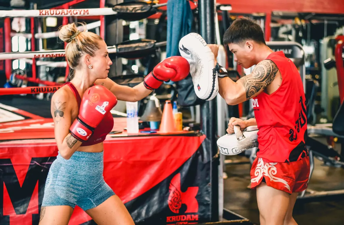 Focused woman enjoying Muay Thai for beginner in a group class at KruDam Gym, training with energy and determination