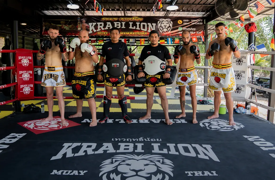 Trainers and students pose together after a Muay Thai training session for all levels at Krabi Lion Muay Thai gym.