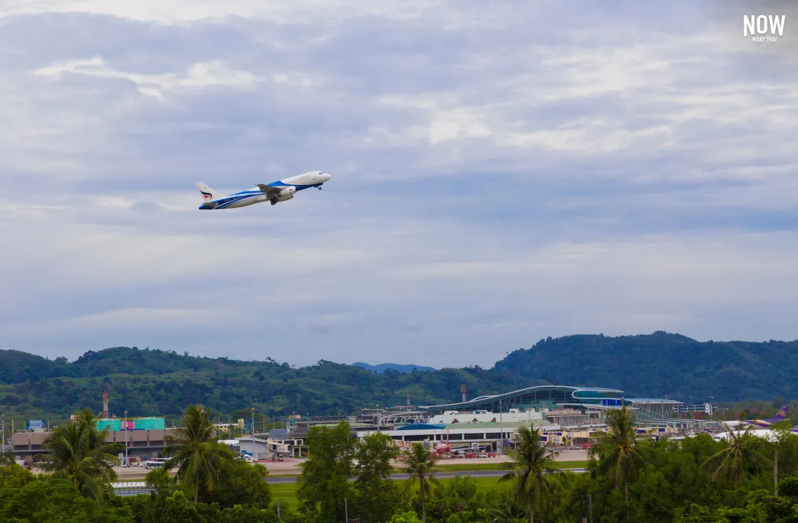 Bangkok Airways plane flying over Phuket International Airport, welcoming travelers to the island's tropical beauty, famous beaches, and rich Muay Thai culture